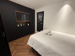 ein Schlafzimmer mit einem weißen Bett und einem Flachbildfernseher in der Unterkunft 658 Suite in Eilat