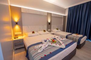 a hotel room with two beds with towels on them at Silver Hotel in Side +75 photos