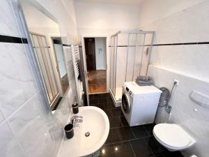 a white bathroom with a sink and a toilet at ✪ FirstClass-Apartment in Leipzig-Gohlis ✪ in Leipzig +10 photos