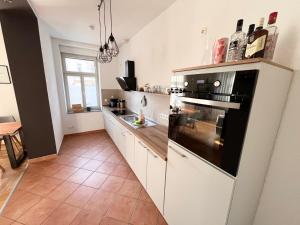 a kitchen with white cabinets and a black oven at ✪ FirstClass-Apartment in Leipzig-Gohlis ✪ in Leipzig
