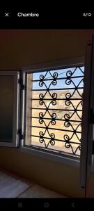 a window with a metal railing in a room at Taghazout oufla in Taghazout
