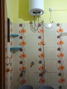 a bathroom with a shower with flowers on the wall at Nandy Delight Homestay in Kanyakumari