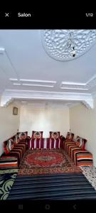 a living room with red leather couches and a ceiling at Taghazout oufla in Taghazout
