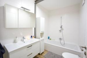 a white bathroom with a sink and a shower at RK Private Residence in Trautmannsdorf an der Leitha