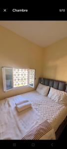 a bedroom with a large bed with a window at Taghazout oufla in Taghazout