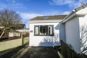 a white house with a window and a fence at Blake Lodge in Newquay