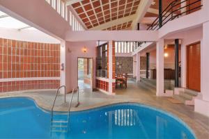 a swimming pool in a building with a house at The Rustic Ridge Villa by StayJadePool1hr E-city in Denkanikottai