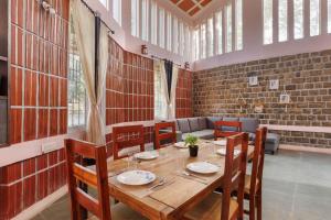 a dining room with a wooden table and chairs at The Rustic Ridge Villa by StayJadePool1hr E-city in Denkanikottai