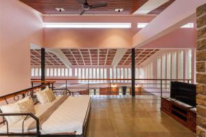 a bedroom with a bed and a tv in a room at The Rustic Ridge Villa by StayJadePool1hr E-city in Denkanikottai