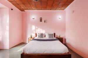 a bedroom with pink walls and a bed with white sheets at The Rustic Ridge Villa by StayJadePool1hr E-city in Denkanikottai +35 photos