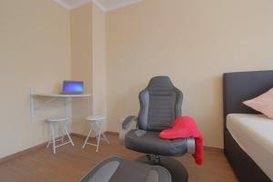 a room with a chair and a table with a laptop at Gästehaus Dorum 02 in Dorum