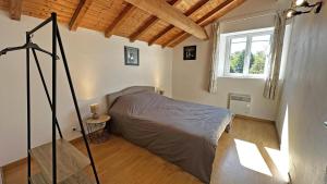 a bedroom with a bed in a room with a window at Neuville in Saint-Mathieu