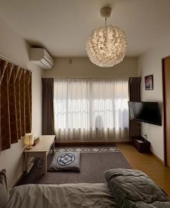 a bedroom with a bed and a chandelier at 青梅森の宿 in Ome