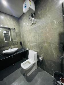 a bathroom with a white toilet and a sink at MK House in Greater Noida