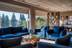 eine Lobby mit blauen Möbeln und einem großen Fenster in der Unterkunft Hotel Ignacio - PalomarGroup in Chiva