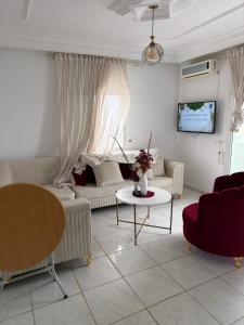 a living room with a couch and a table at honey moon zeinbe 3 in Hammamet