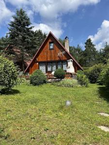 a large wooden house in the middle of a field at chata u Ondrucha in Tři Studně