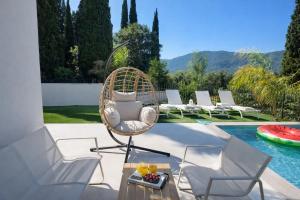 a wicker chair sitting on a patio next to a pool at Villa Harmony Luxury Resort in Corfu
