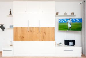 a room with a tv on a white wall at Hanseatic 111 in Duhnen