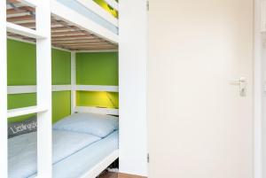a bunk bed in a room with green walls at Hanseatic 111 in Duhnen