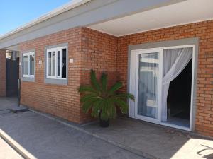 a brick building with a window and a plant at Loft e casa Catarina in Imbituba