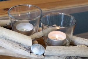 two candles sitting on top of a wooden table at KA8 Beim Wattn Fischer in Wremen