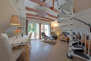 a spiral staircase in a living room with a table and chairs at KA8 Beim Wattn Fischer in Wremen