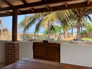 a porch with a table and a view of the beach at Aki Villa in Pasikuda