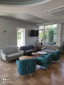 ein Wohnzimmer mit Sofas, Sesseln und Tischen in der Unterkunft Helios Hotel in Baltschik