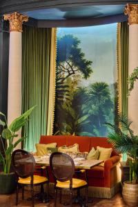 a living room with a couch and a table and chairs at The Queens Hotel in Leeds