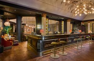 a bar in a restaurant with stools at The Queens Hotel in Leeds