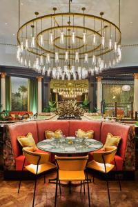 a dining room with a table and a large chandelier at The Queens Hotel in Leeds