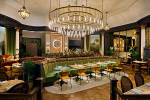 a dining room with tables and a chandelier at The Queens Hotel in Leeds
