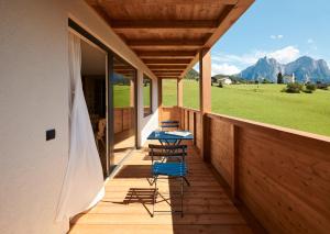 two chairs and a table on the porch of a house at Alpe di Susi in Castelrotto