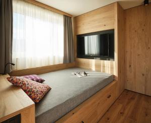 a bedroom with a large bed with a flat screen tv at Alpe di Susi in Castelrotto