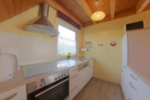 a kitchen with a sink and a stove at SR Eversand 11 in Dorum-Neufeld +7 photos