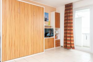 a living room with a large wooden cabinet with a tv at Hanseatic 210 in Duhnen