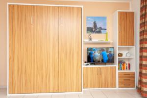 a living room with a tv in a wooden cabinet at Hanseatic 210 in Duhnen