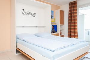 a bed in a room with a white wall at Hanseatic 210 in Duhnen