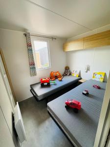 a room with two beds with toy cars on them at Camping Les Payolles in Saint-Georges-dʼOléron