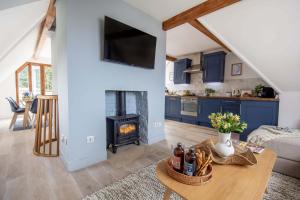 a kitchen and living room with a fireplace in a house at 1 Quay Cottage in Bawdsey