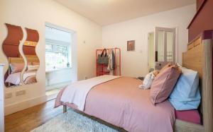 a bedroom with a bed and a large window at 1 Quay Cottage in Bawdsey