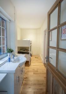 a bathroom with a white sink and a wooden floor at 1 Quay Cottage in Bawdsey +40 photos