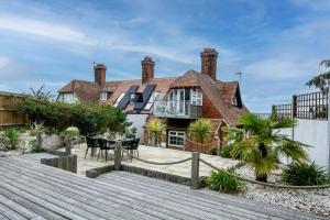 a house with a wooden walkway in front of it at 1 Quay Cottage in Bawdsey