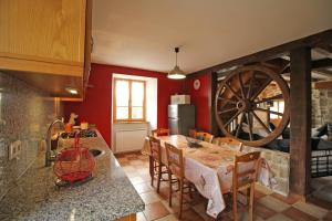 a kitchen with a table and a wooden wheel at La chaudière in Saint-Auvent
