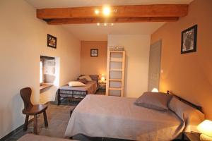 a bedroom with a bed and a chair in a room at La chaudière in Saint-Auvent