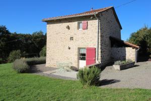 a small stone building with a red door at La chaudière in Saint-Auvent