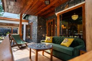 a living room with a green couch and a table at Secret Garden Kalam in Kalām