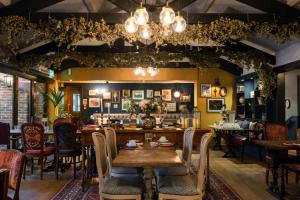 a restaurant with tables and chairs in a room at Rose And Crown Hotel in London