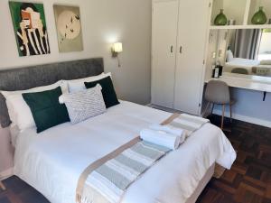 a bedroom with a white bed with towels on it at Easy Inn Guesthouse in Welkom +24 photos
